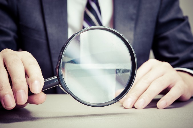 虫眼鏡を持つビジネスマン